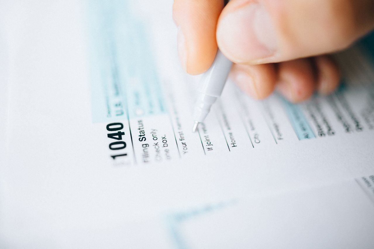 Close-up of a hand filling out a Form 1040 tax return